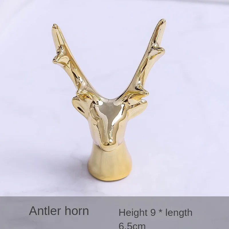 Gold-colored antler horn jewelry holder with a stylized deer head design