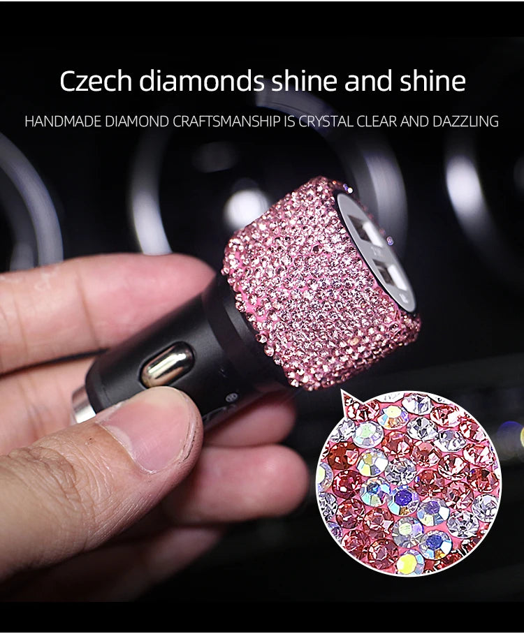 A hand holds a pink rhinestone crystal clear and dazzling product, likely a dual USB car charger.