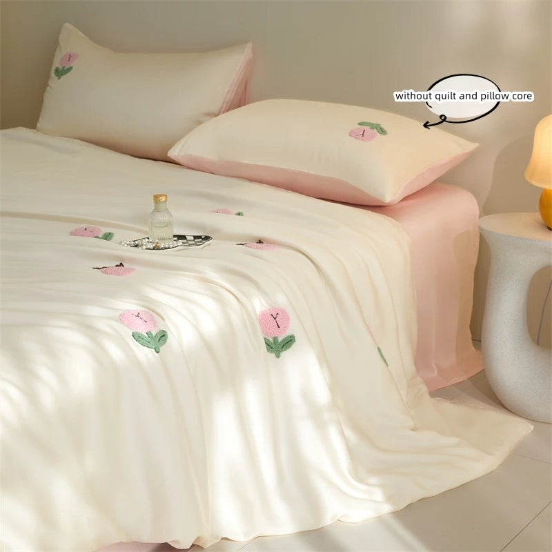 A pink embroidered tulip duvet cover set with matching pillowcases on a bed.