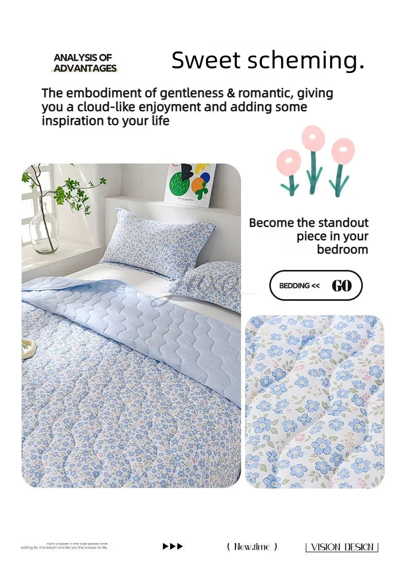 A light blue quilted blanket with a floral pattern is displayed on a bed, emphasizing a sweet and romantic theme.