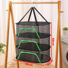 A folding wooden rack holds a black mesh hanging drying net with green accents.