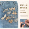 Silver and gold butterfly-shaped clasps for adjusting the waist of denim clothing
