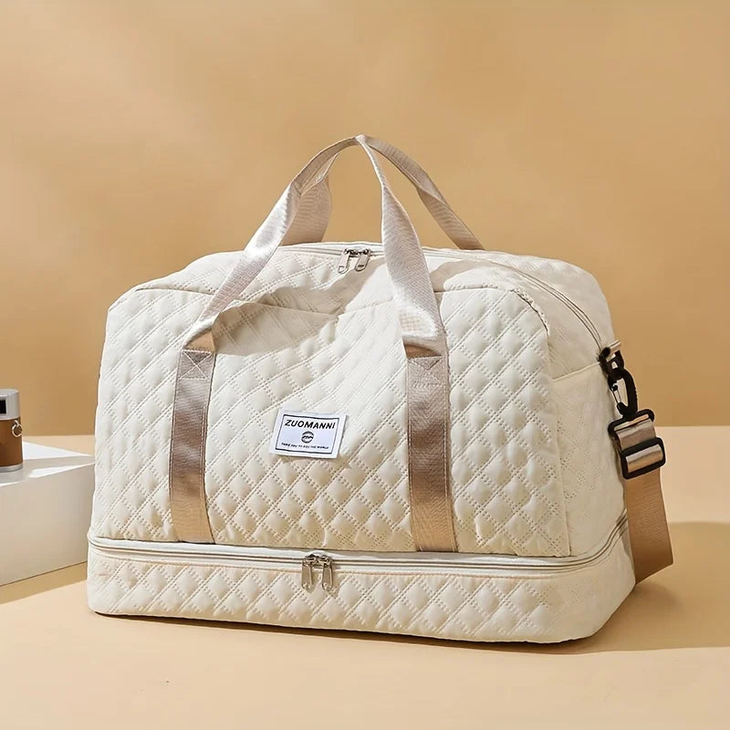 A cream-colored lightweight nylon travel duffle bag with tan straps and a gold accent.