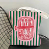 A pink and green striped tote bag featuring a red illustration of sardines.