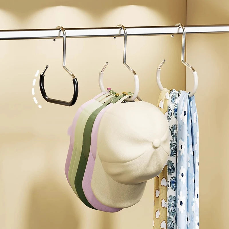 A set of rust-resistant steel round hanger hooks hanging on a bar, with a light-colored hat and a blue patterned scarf visibl