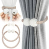 Pearl magnetic curtain tiebacks with a beige cord and pearl accents shown in use on a gray curtain.