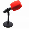 Red foam windscreen for a handheld microphone with a black stand.