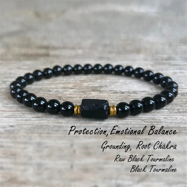 A black tourmaline bracelet with a black stone and gold accents, used for protection and grounding.