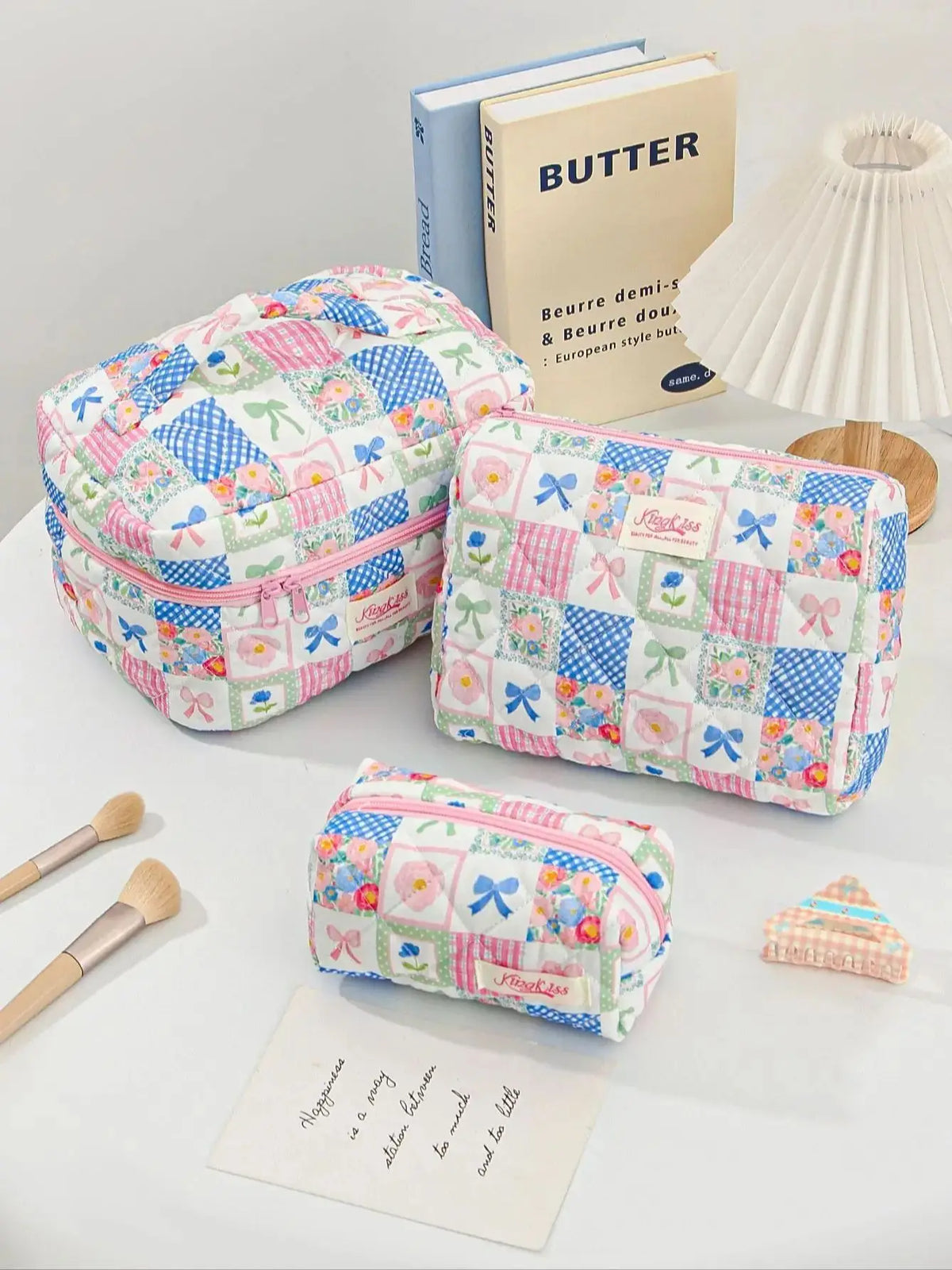 A patchwork quilted makeup bag featuring a colorful floral and geometric pattern in pink, blue, and green fabrics.