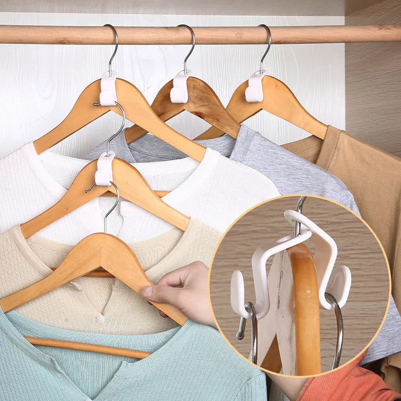 A close-up of a wooden hanger with white plastic connectors used to hang clothing.