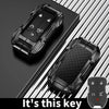 A black zinc alloy key fob case for a Chevy Silverado or GMC Sierra vehicle is shown on a dark surface.