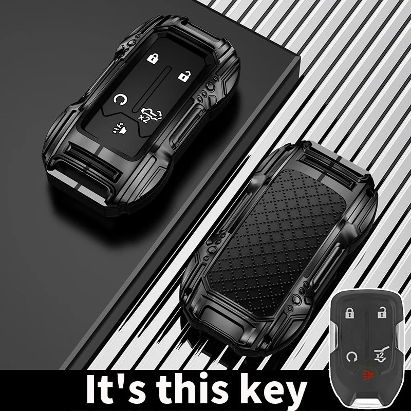 A black zinc alloy key fob case for a Chevy Silverado or GMC Sierra vehicle is shown on a dark surface.