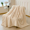A thick, cream-colored flannel blanket draped on a light-colored floor.