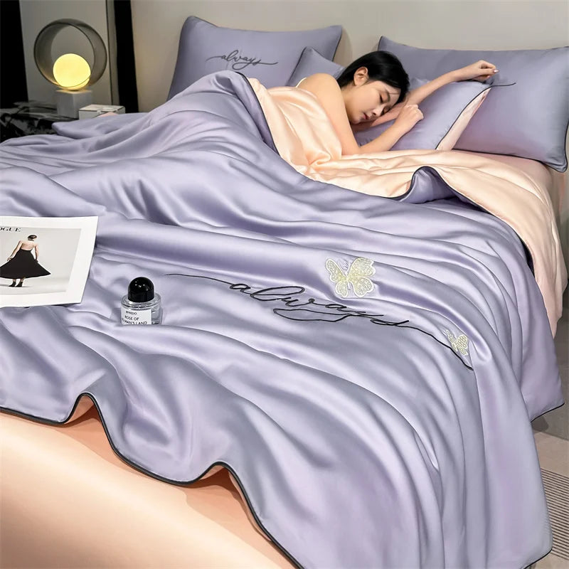 A person is lying on a purple comforter featuring silver embroidery of butterflies.