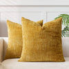 A close-up of a golden yellow handwoven chenille texture cushion cover resting on a light sofa.