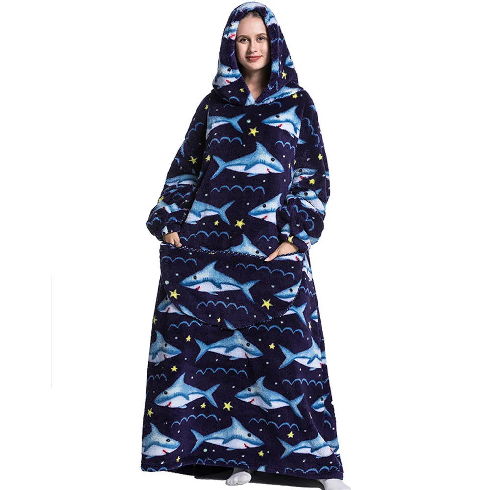 A woman wearing a navy blue patterned wearable blanket hoodie with a hood and sleeves.