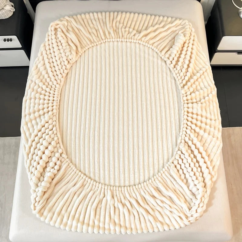 A round, thick knit fitted bed sheet in cream color with a textured, ribbed edge.
