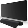 A black extended anti-slip desk pad with stitched edges lying on a white surface.