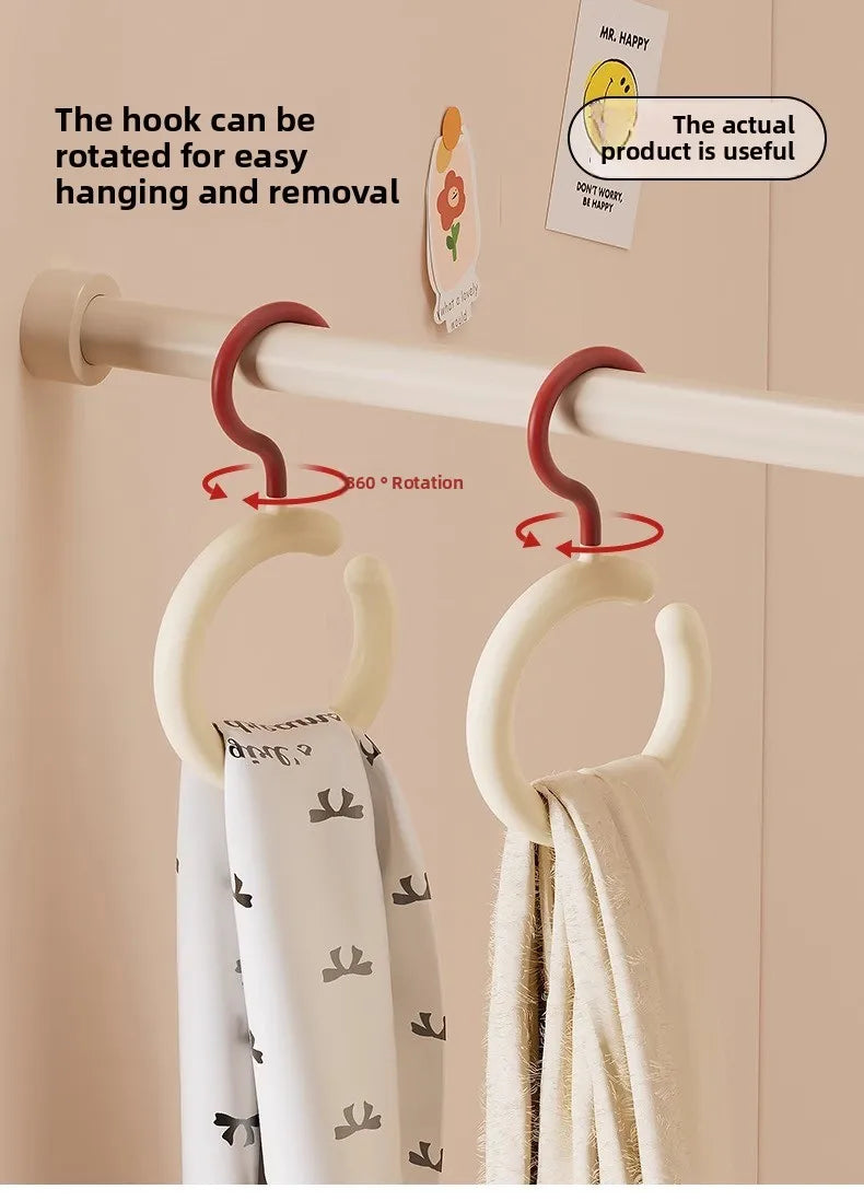 A white wall hook is shown rotating to easily hang and remove a fabric item like a scarf or hat.