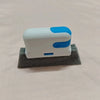 A white and blue multi-purpose crevice cleaning brush resting on a gray felt surface.