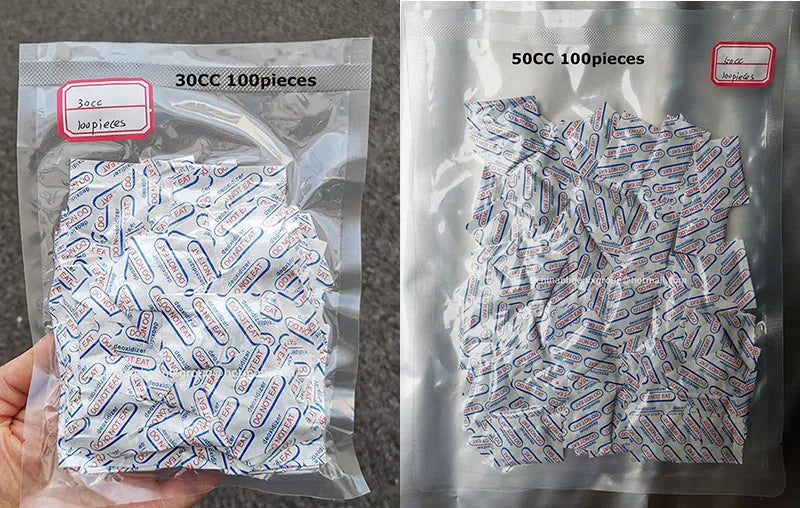 A hand holds a clear plastic bag containing 100 food grade oxygen absorbers for long-term dry food storage.