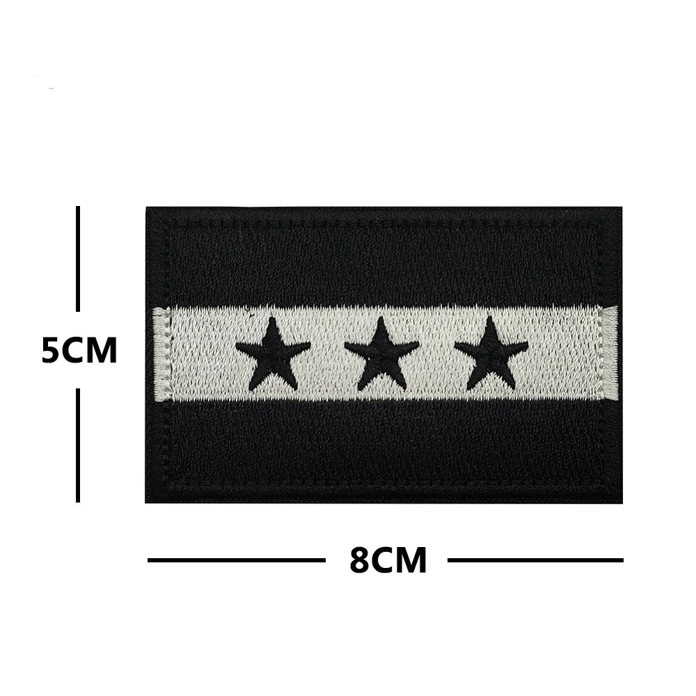 Black flag patch with three silver stars embroidered on a white stripe.