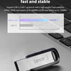 A silver Lexar M400 USB 3.2 flash drive is shown resting on a dark gray laptop surface.