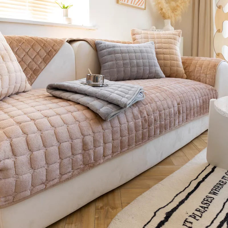 A beige velvet sofa cushion cover featuring quilted fabric and gray accent pillows.