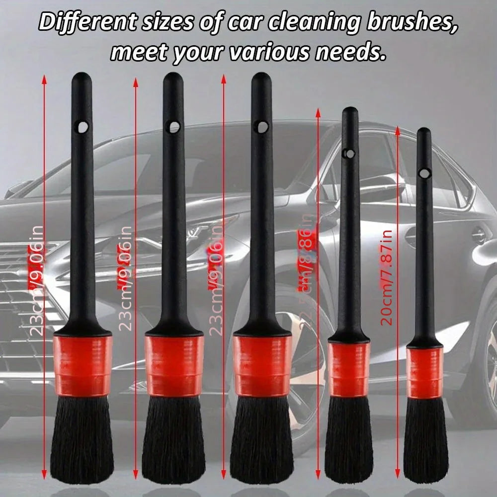 A set of different sized black and red car cleaning brushes displayed in a row.