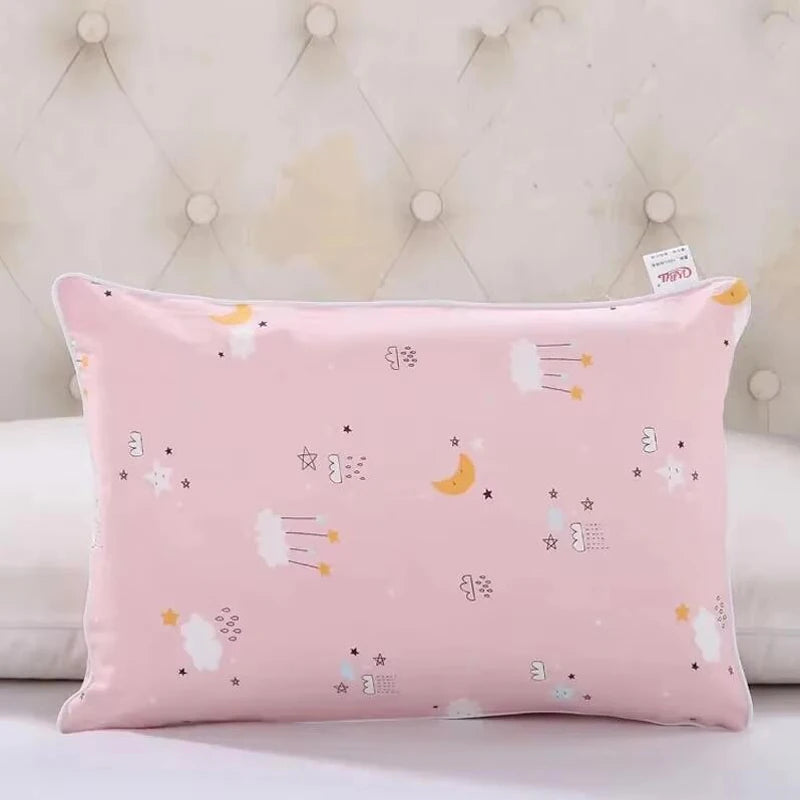 A pink cartoon pillowcase with stars and clouds is displayed on a white surface.