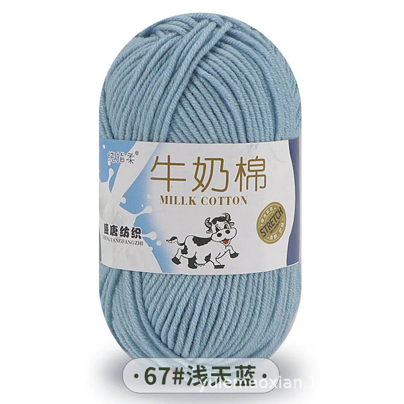 A ball of light blue milk cotton blend yarn with a label in Chinese and English.