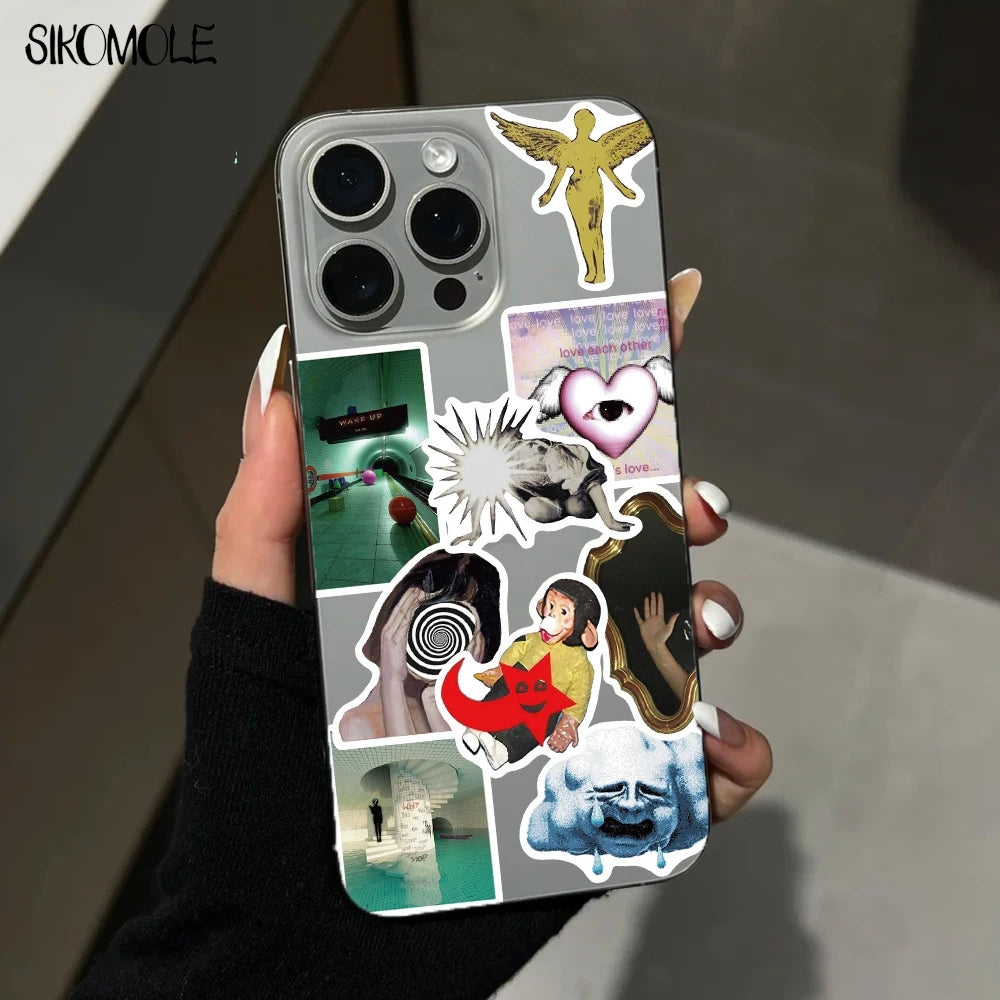 A hand holds a phone case featuring various cartoon and abstract art stickers on a dark background.