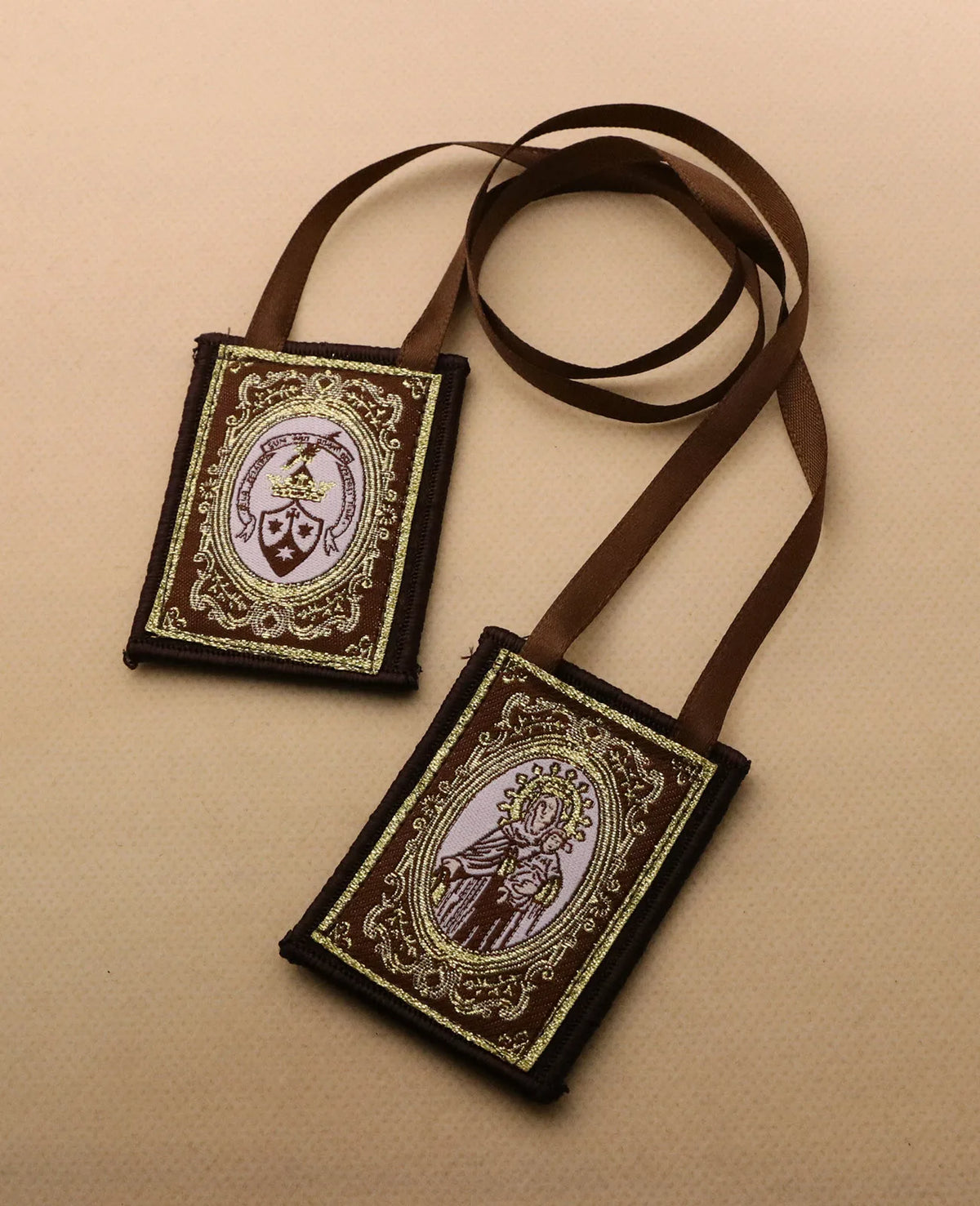 A brown leather scapular necklace featuring an immaculate heart pendant on a gold-colored chain.