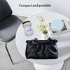 A black compact contact lens travel case is displayed on a white table next to a chair.
