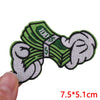 A set of embroidered iron-on patches featuring green fabric with the text 'ECO' and dollar signs.