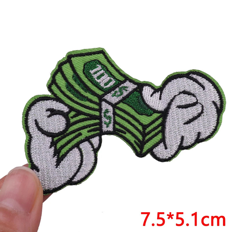 A set of embroidered iron-on patches featuring green fabric with the text 'ECO' and dollar signs.