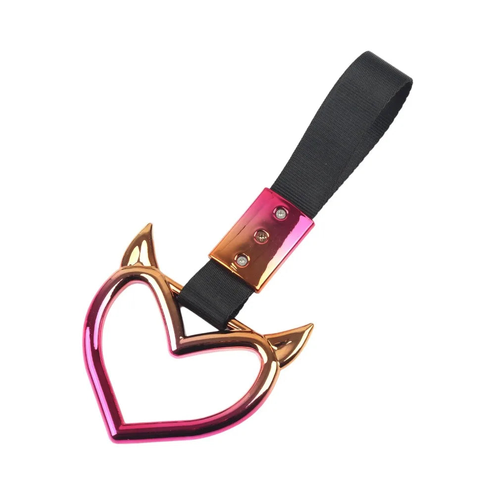 Heart-shaped car handle decor featuring a holographic finish and black strap.