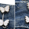 Silver butterfly buttons attached to denim fabric, used as no-sew adjustable waist tightener buttons for jeans.