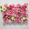 A dense wall panel of pink and cream silk rose flowers for weddings and events.