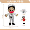 A soft plush hand puppet of a zombie boy with black hair and a red mouth wearing a white shirt.