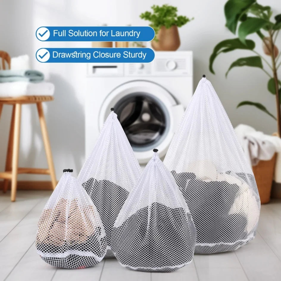 A pack of four white mesh laundry bags with drawstring closures displayed on a light wooden floor.