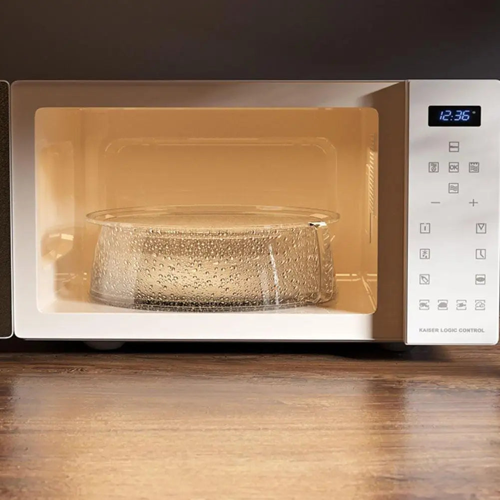 A clear microwave splatter cover with a heat-resistant handle is placed inside a beige appliance.