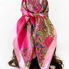 A vibrant pink and leopard print paisley square scarf tied around a woman's hair.