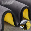 Close-up of a thick gray microfiber car cleaning towel with a yellow lining, showing fine edge workmanship.