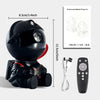 A black astronaut projector night light with a remote control and cables.