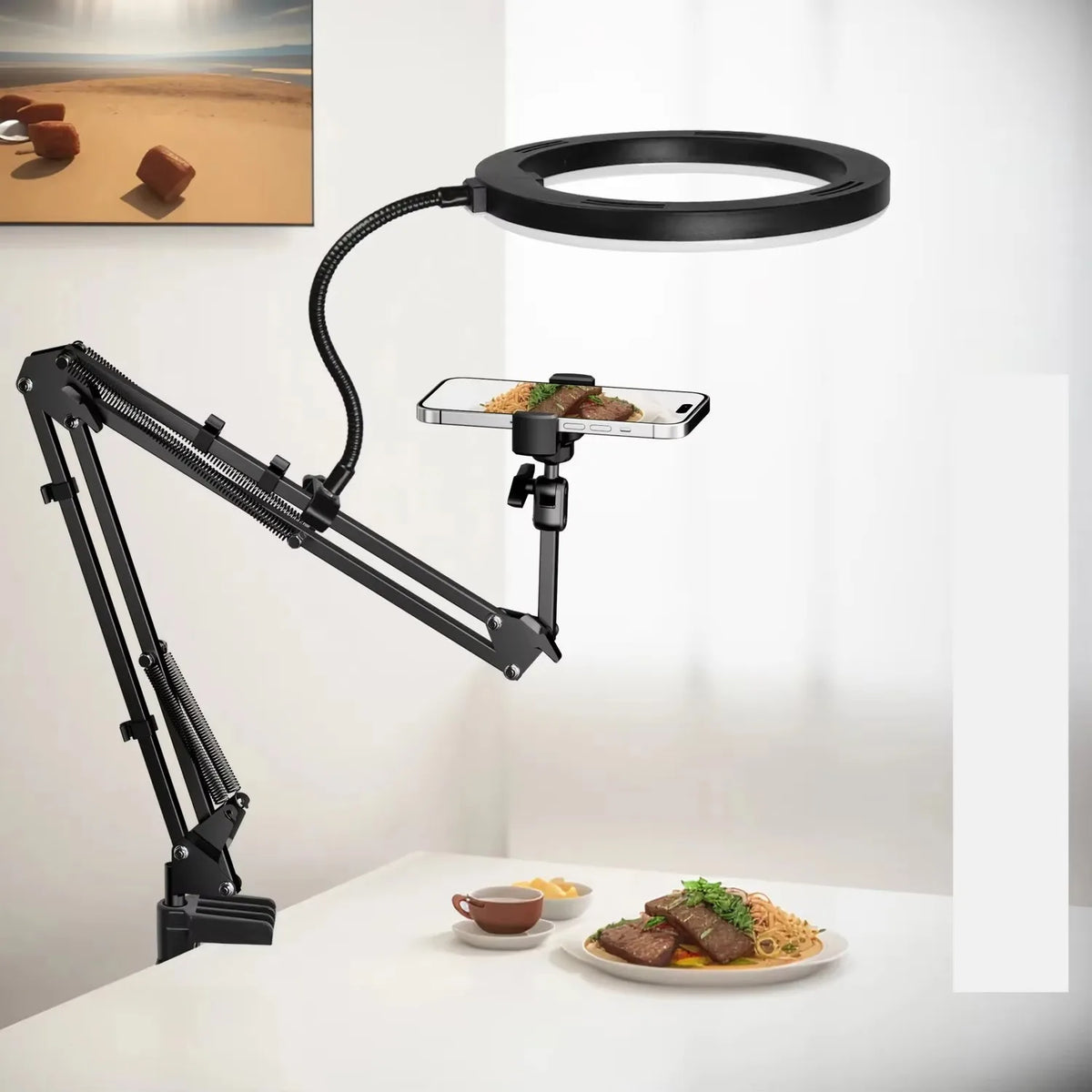 A black adjustable phone stand with an overhead light illuminates a plate of food on a white table.