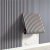 A close-up of a vertical, ribbed gray peel-and-stick wall tile installed on a light-colored wall.