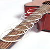 A close-up of a classical guitar fretboard with several coiled strings and a 3-in-1 winding tool.