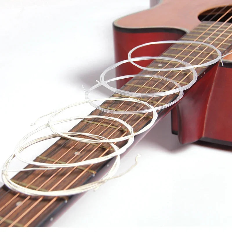 A close-up of a classical guitar fretboard with several coiled strings and a 3-in-1 winding tool.