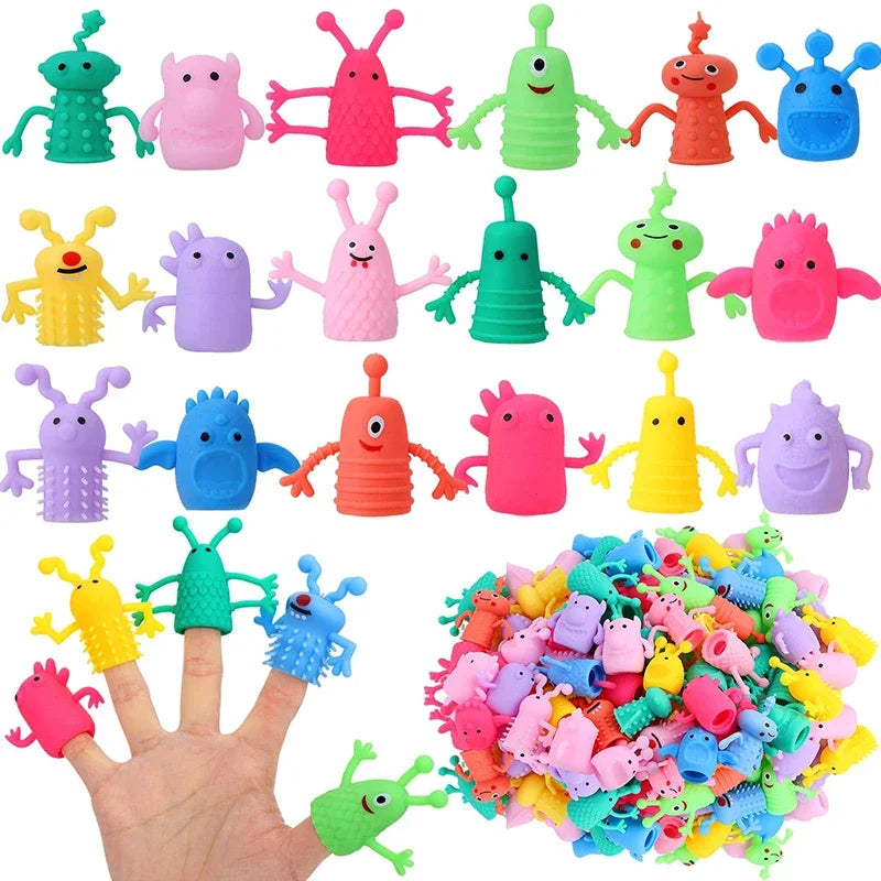 A hand holds a large pile of colorful, cute monster finger fidget toys in various colors like green, pink, yellow, and blue.